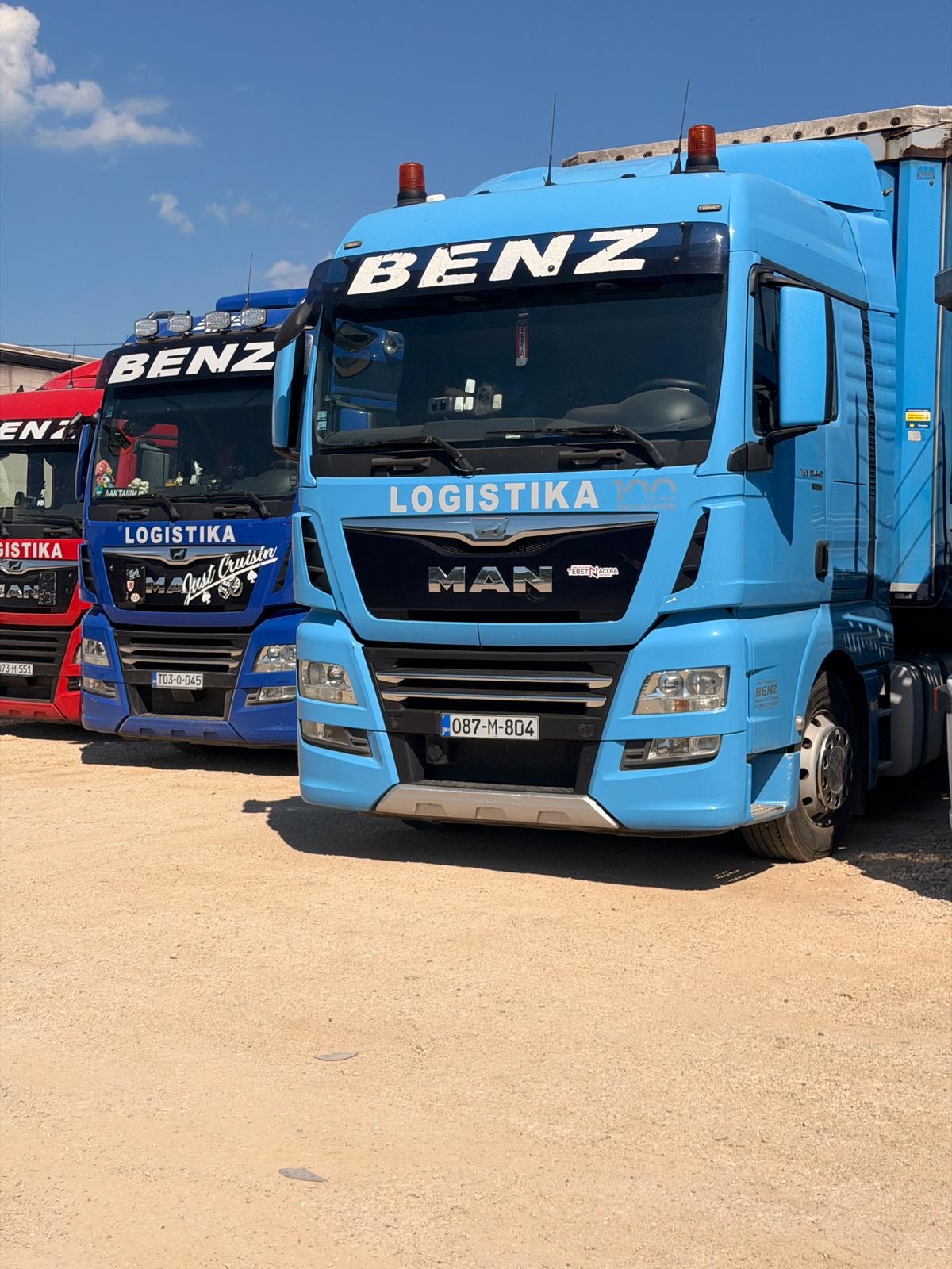 Blizu svetloplavi MAN kamion pored tamnoplavog kamiona sa BENZ LOGISTIKA oznakom